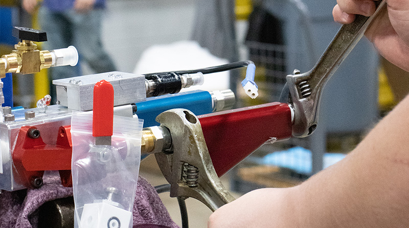 Service technician adjusting pieces of slug gun pro foam injection equipment from FSI