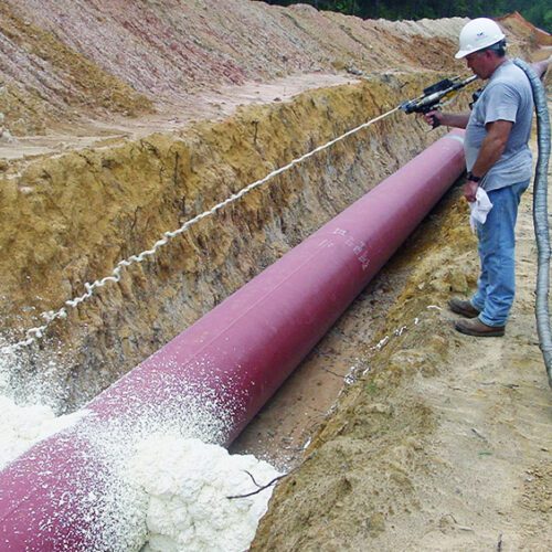 worker spraying polyurethane foam trenchbreak from FSI onto pipeline
