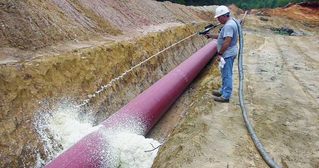worker spraying polyurethane foam trenchbreak from FSI onto pipeline
