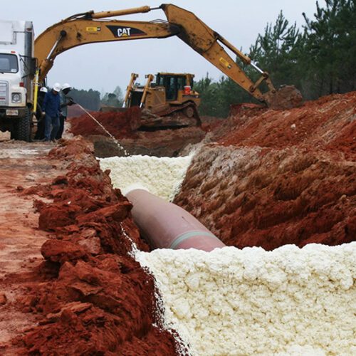 workers spraying trench break geotechnical foam from FSI as part of installing pipeline