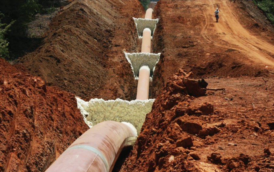 worker walks alongside massive pipeline with foam trench breakers from FSI
