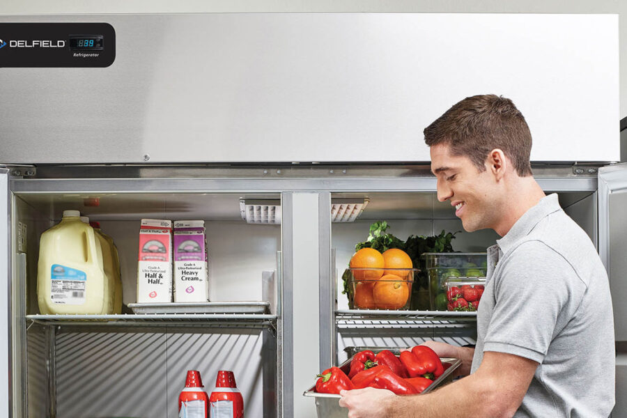 man getting food out of refrigerator | Delfield refrigerator