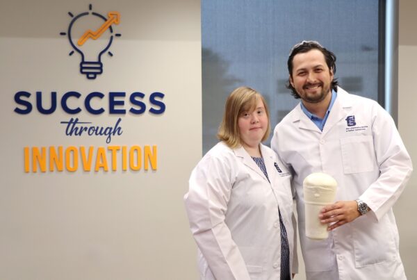 A man and woman in lab coats with a polyurethane foam experiment.